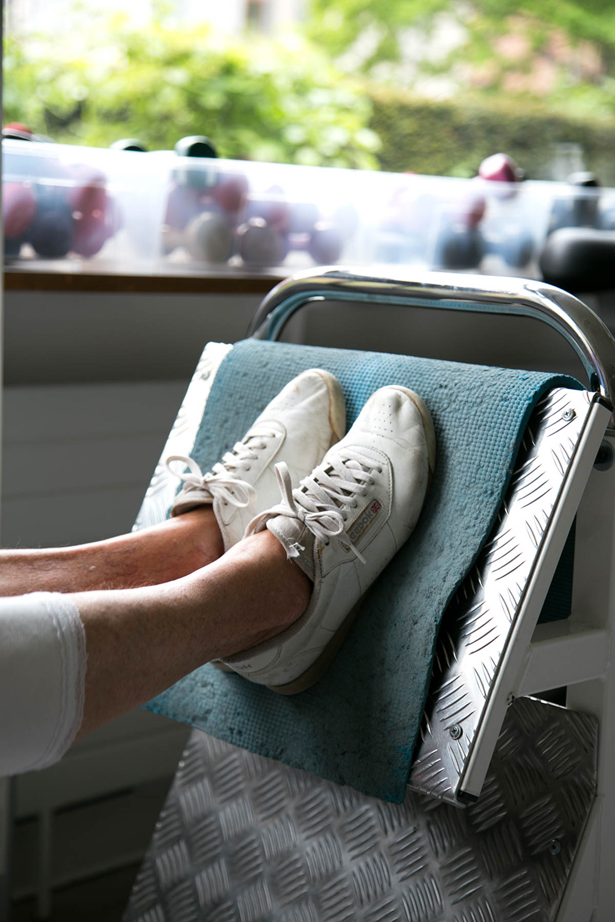 Deltager træner i fitnessmaskine med instruktør i nærheden