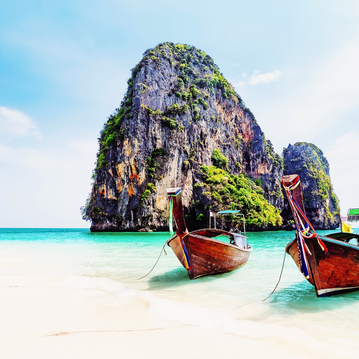 Thailandsk kyst med longtail-både – stemning fra Thailand til sprogkursus.