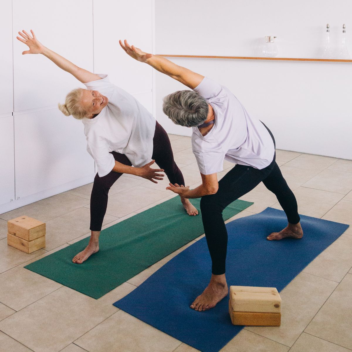 To kursister laver øvelse til Pilates og Yoga i FOF.