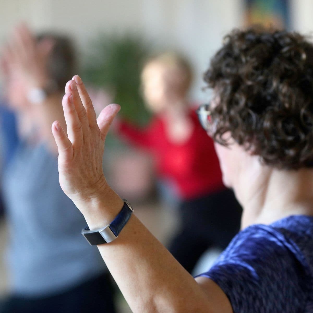 Deltager der laver yogaøvelse til skånsom yogaundervisning.