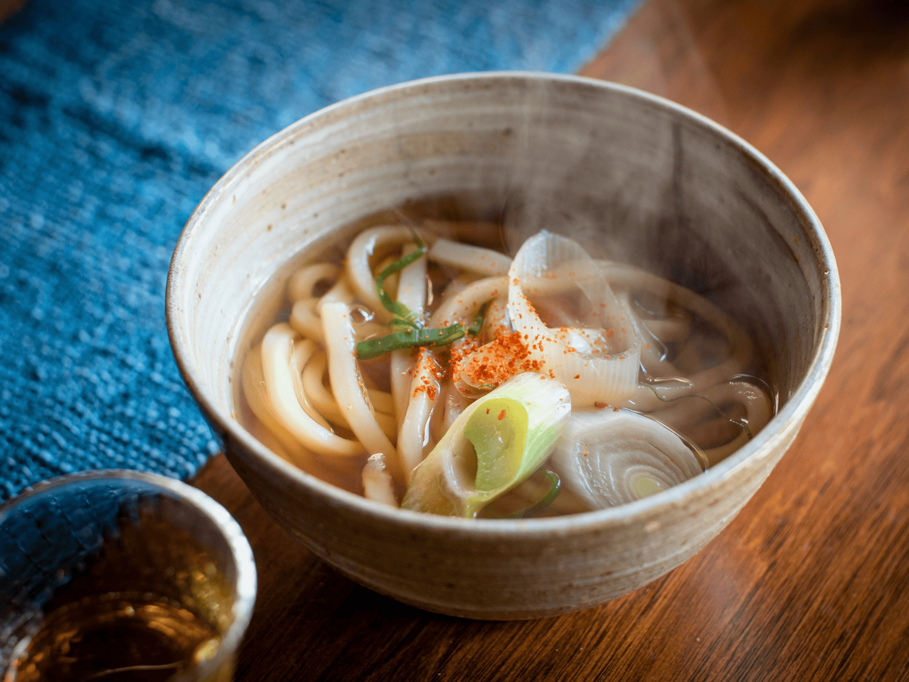 Bowl of homemade udon noodles in clear broth with vegetables