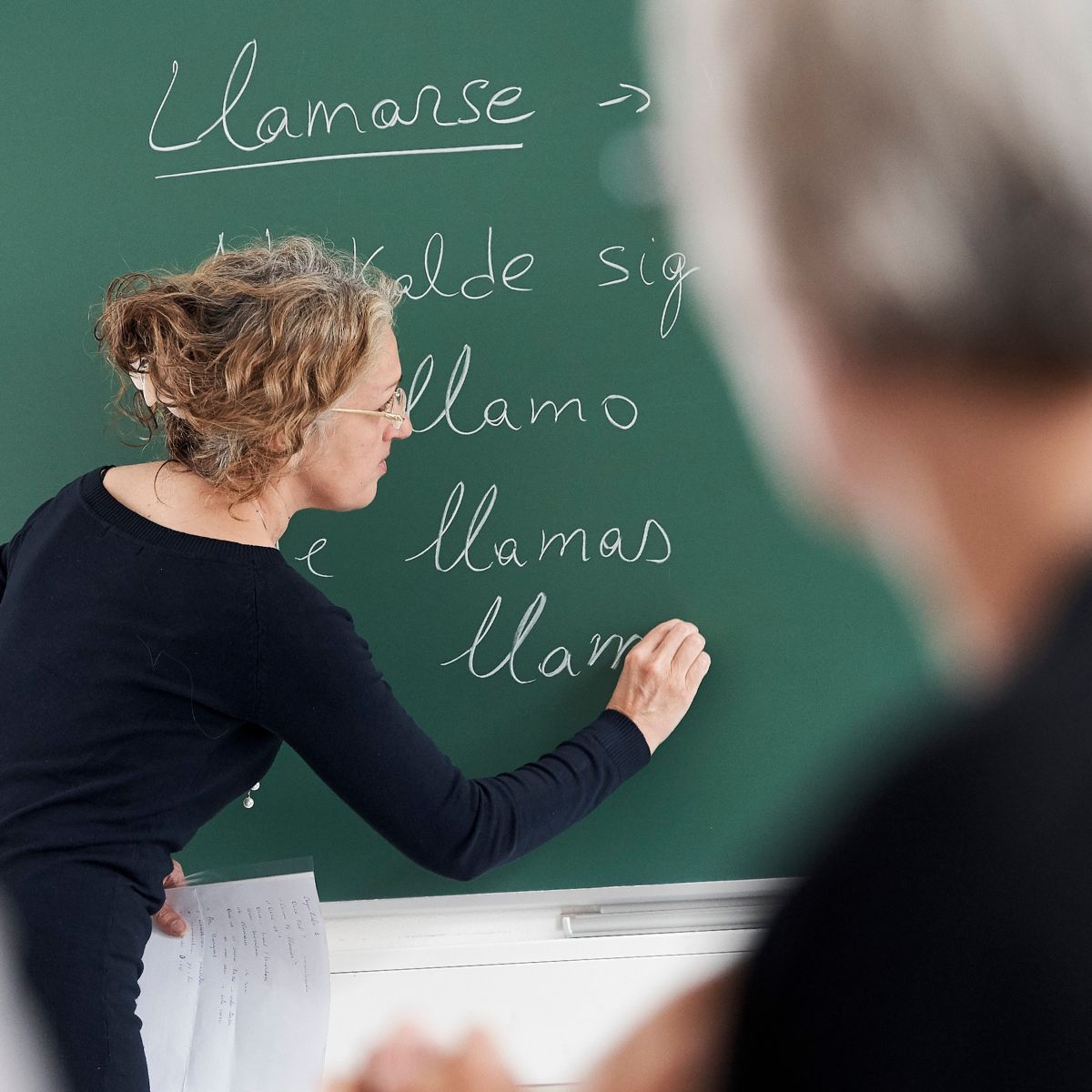 Spanskunderviser der skriver på tavlen