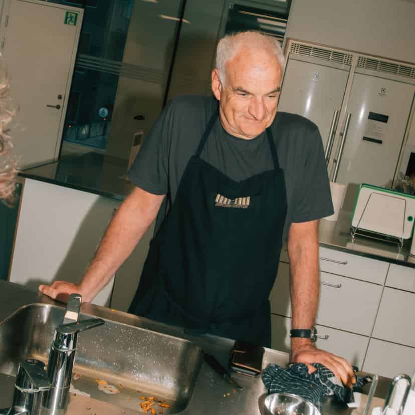 mand med forklæde i køkkenet