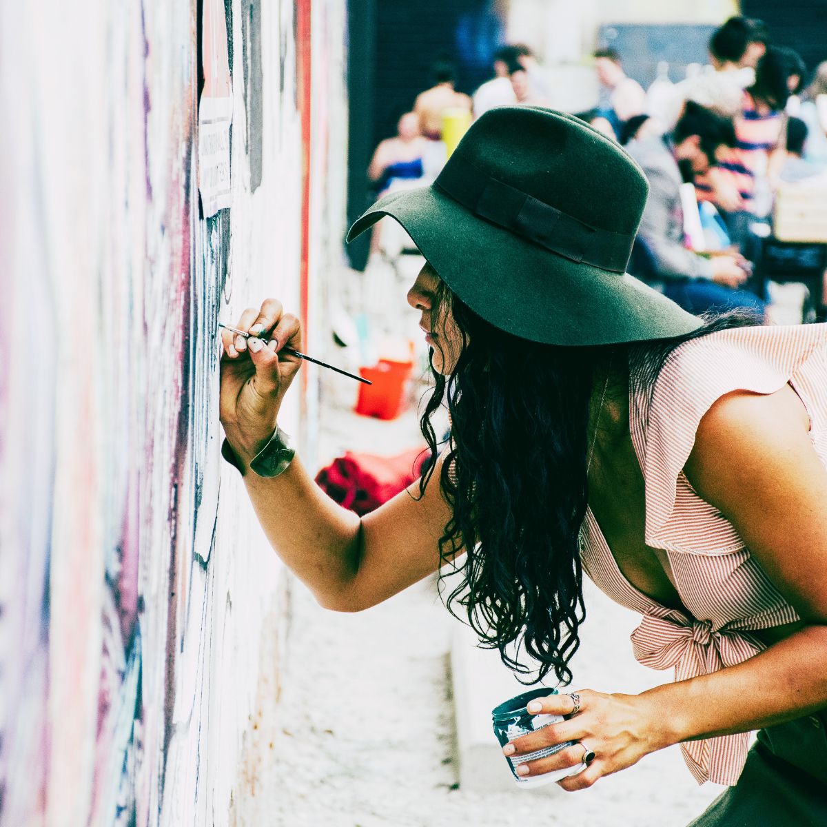 Deltager arbejder koncentreret med maleri på et malekursus