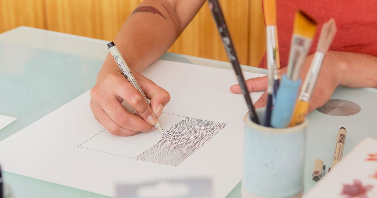 "Deltagere tegner med blyant på papir under kreativ tegneworkshop i Glostrup Medborgerhus"