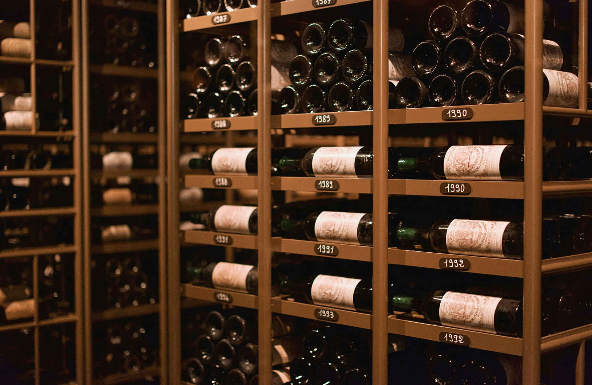 Vinflasker i vinkælder med årgange på hylder