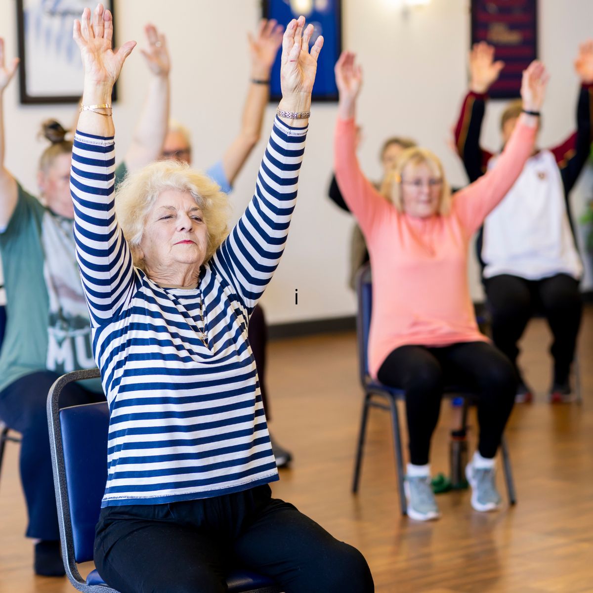 Ældre deltager laver skånsom træning siddende på stol med fokus på bevægelse balance og afspænding