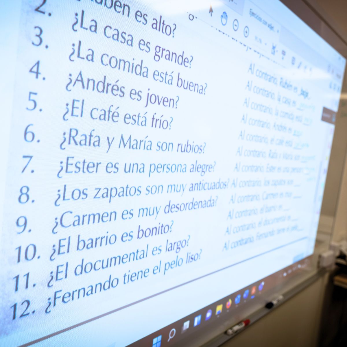 Billede af digital tavle med en masse spanske sætninger