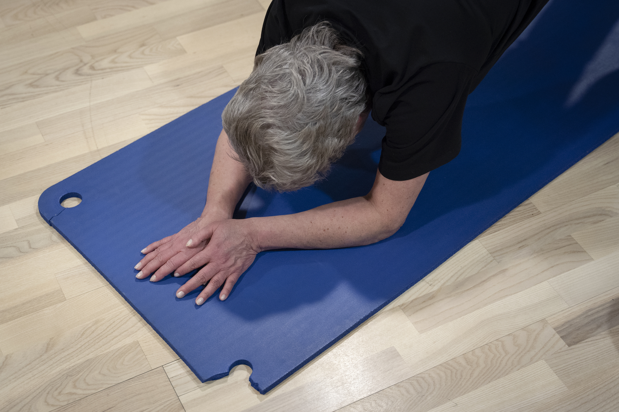 Deltager udfører rolige strækøvelser på måtte