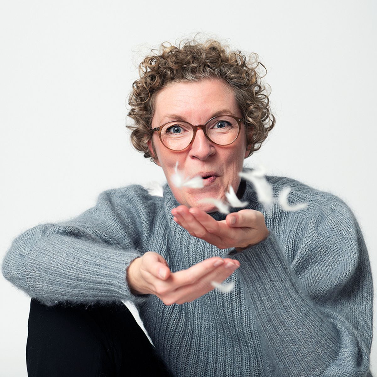 Underviser der puster fjer fra sin hånd