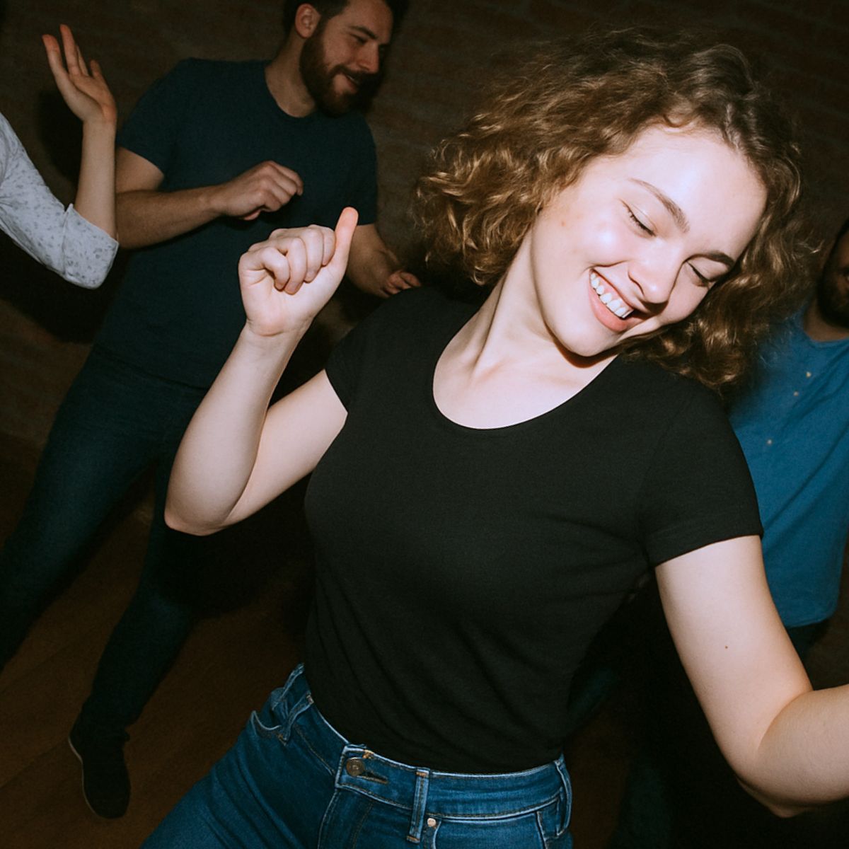 en pige der danser frit efter rytmen, med folk dansene bag hende