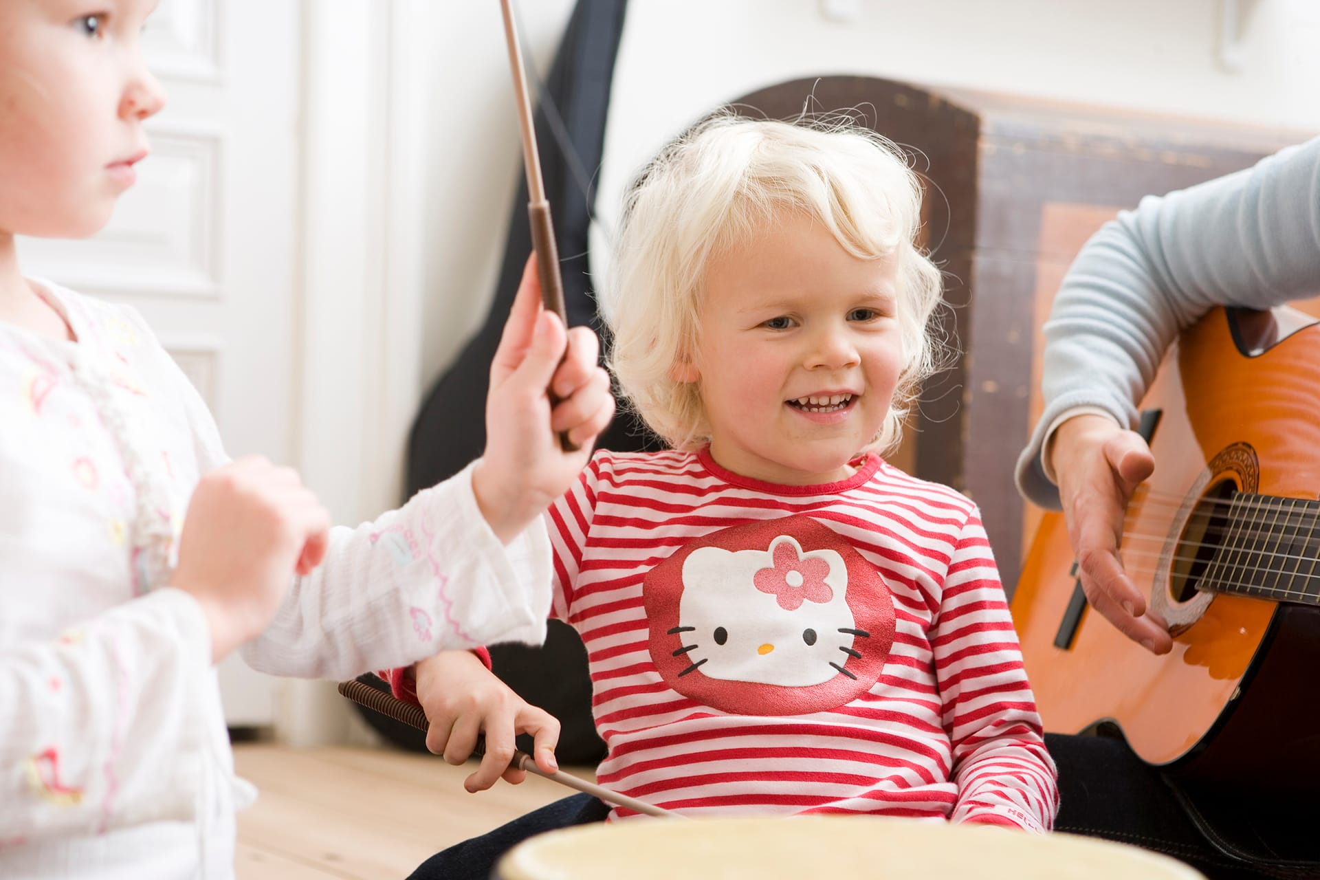 Forælder og barn leger med rasleæg i rytmiktime.
