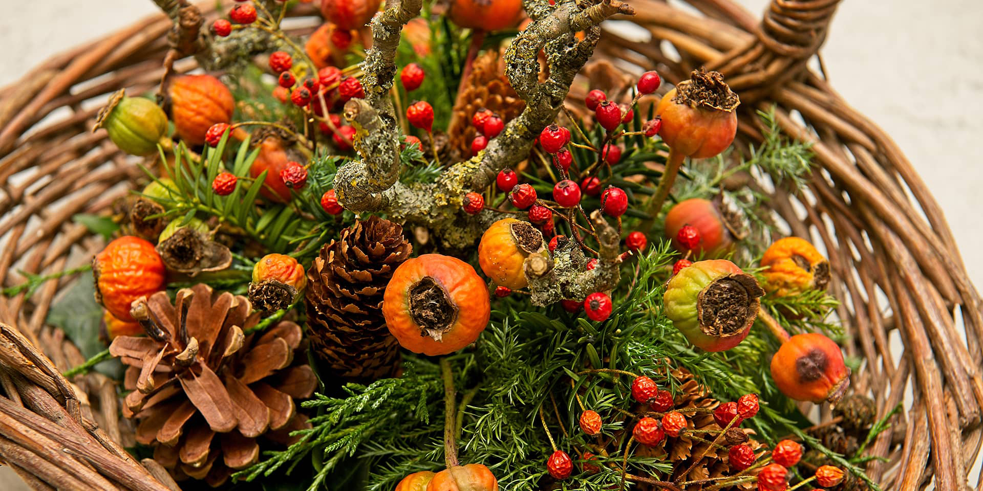 Julebuket. Grankogler, røde og orange blomster fra et kursus i blomsterdekoration - advent og jul - i FOF Aarhus