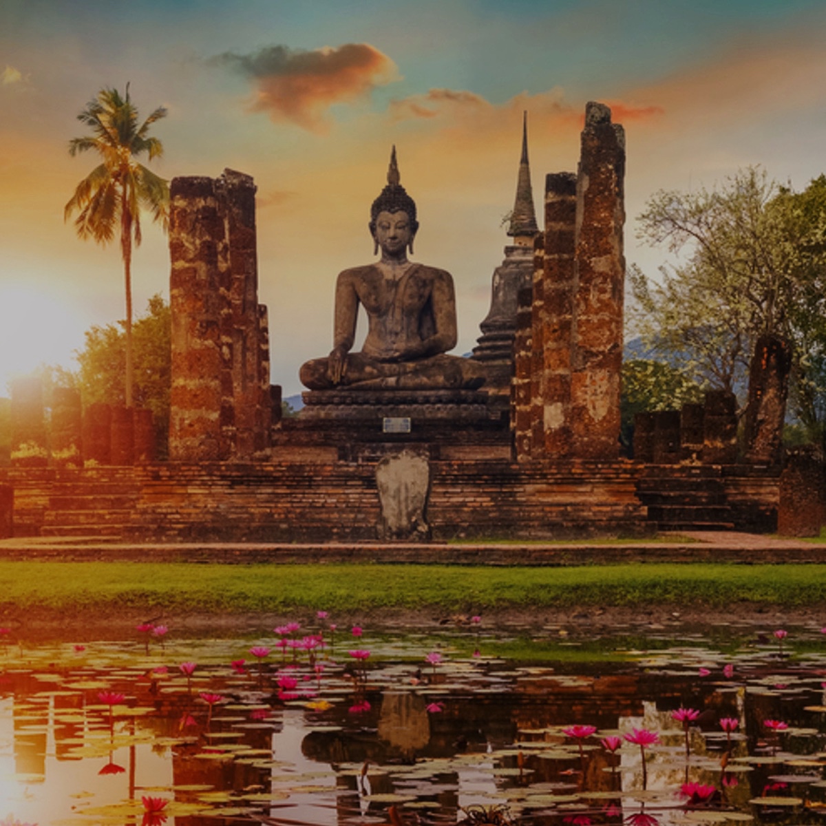 Buddha-statue i tempelområde ved solnedgang – symbol på thailandsk kultur