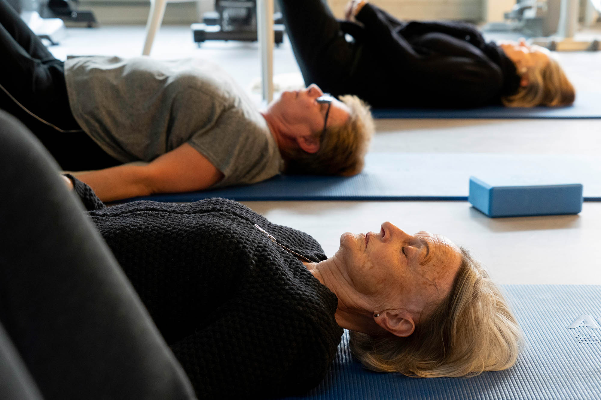 Kursister laver blid yoga og åndedrætsøvelser på holdet Kom videre efter stress med yoga hos FOF København og Nordsjælland.