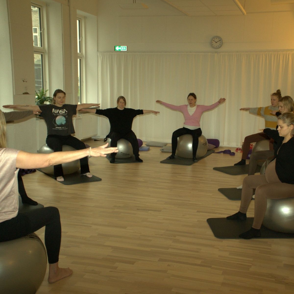 Kvinder laver yoga-øvelse på kursus for gravide i FOF Aftenskolen Aarhus