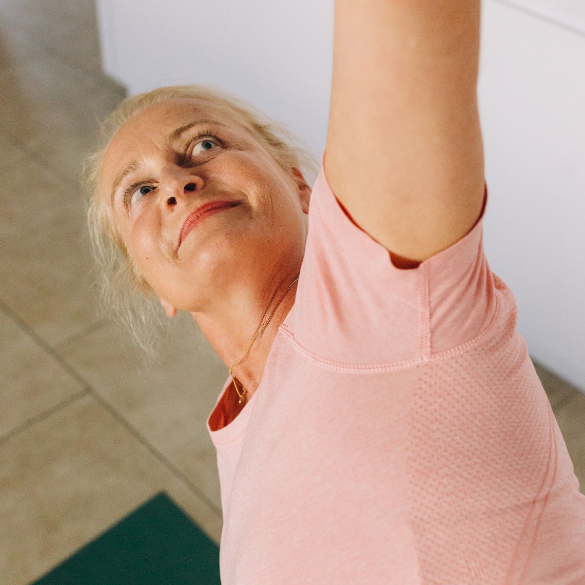 Glad kursist lave øvelse på måtte til Pilatesinspireret Yoga hos FOF.