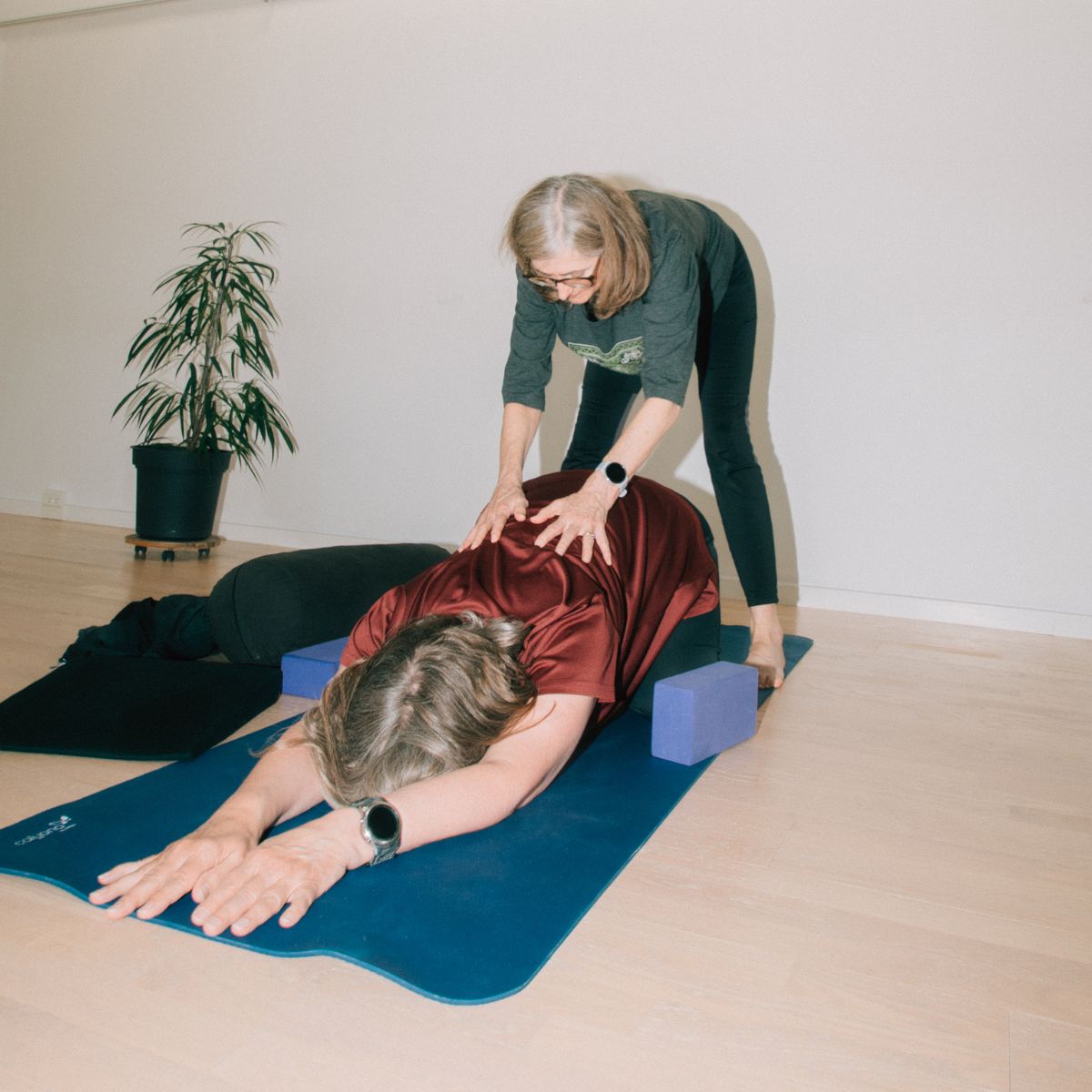 Yogalærer hjælper kursist med skånsom yoga