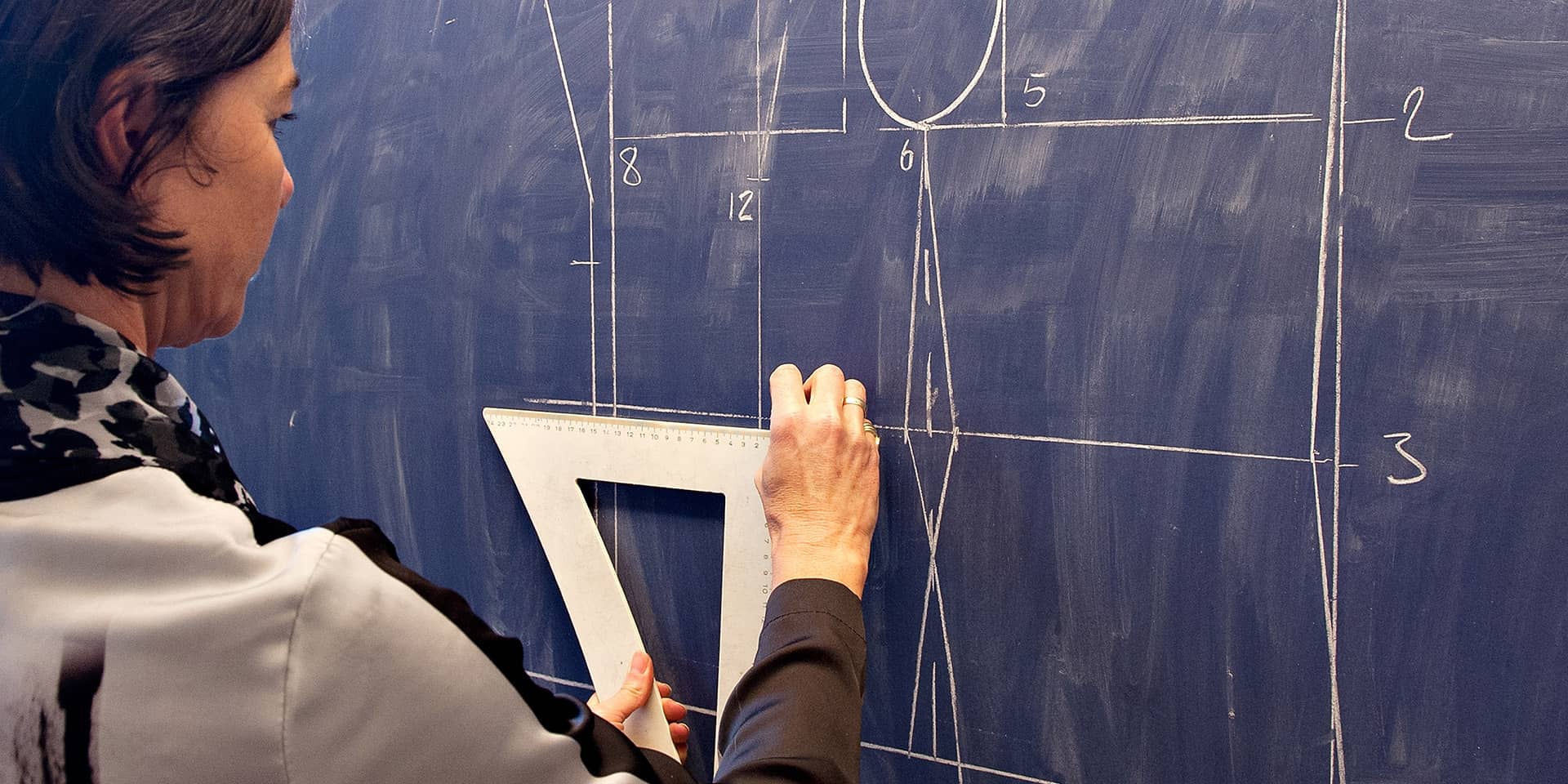 Kursist tegner mønster på en tavle til sykursus i FOF Aarhus