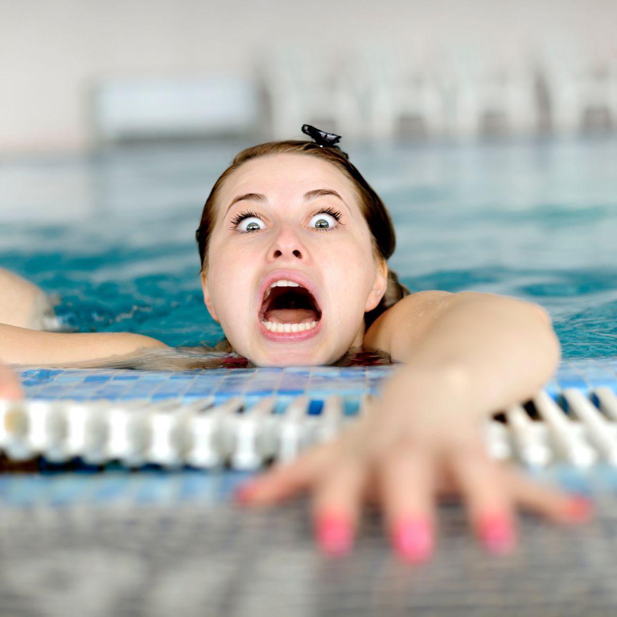 Deltager lærer trygt at bevæge sig i vandet sammen med instruktør i svømmehal. Rolig og tillidsfuld stemning i bassinet.