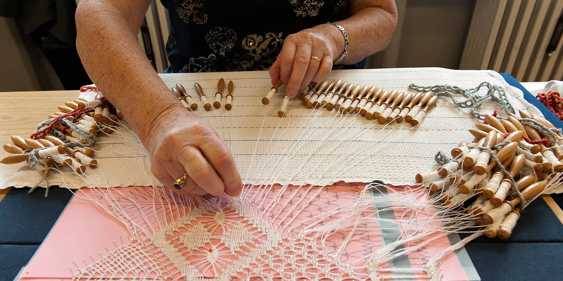 Hænder, der knipler til et kreativt kursus i knipling i FOF Aarhus