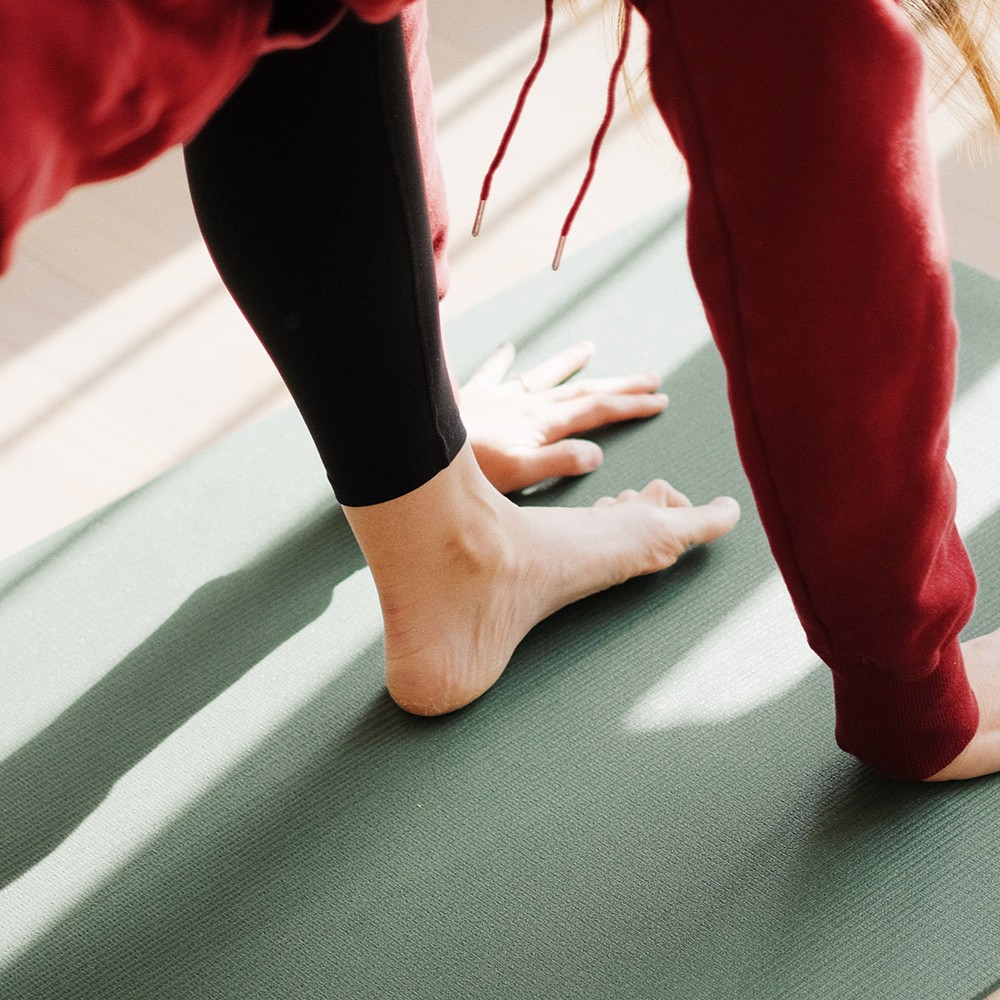 fod og hænder på yogamåtte