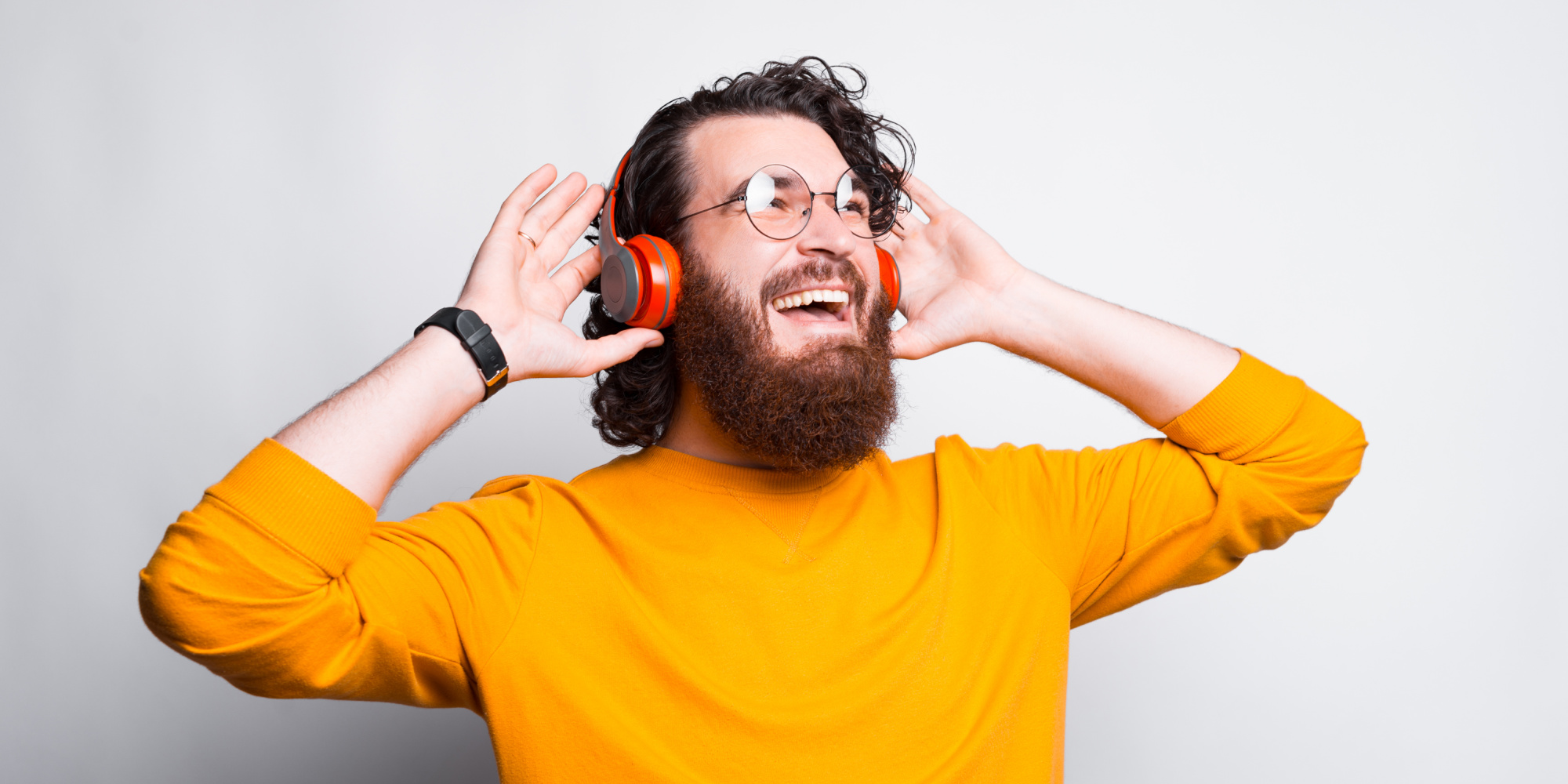 Mand i gul trøje som er glad og lytter til musik